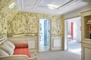 a room with yellow walls with floral wallpaper at Le Meurice – Dorchester Collection in Paris