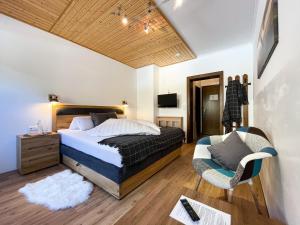una camera da letto con un letto e una sedia di Zirbenhof a Innerkrems