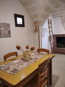 uma mesa de jantar e cadeiras com um vaso em Casa Antica em Fasano
