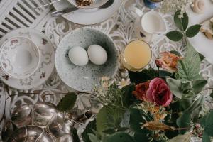 two eggs are sitting on a table with flowers at Hoby Kulle Herrgård B&B in Bräkne-Hoby +21 photos