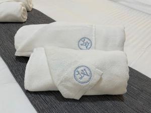 two towels sitting on top of a bed at La Veranda Hotel in Larnaca