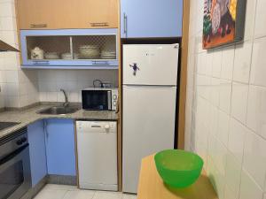 a small kitchen with a refrigerator and a microwave at SAN VICENTE DO MAR (URBANIZACIÓN PEDRAS NEGRAS) O GROVE- SANXENXO in O Grove