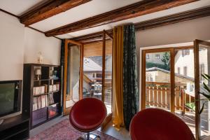 ein Wohnzimmer mit einem TV und einem Balkon in der Unterkunft Le Balcon du Château - Aprtement 75 square meter in the Annecy center in Annecy