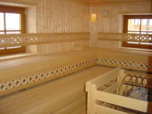 an empty sauna with wooden floors and wooden shelves at Hochberghaus Resort in Grünau im Almtal