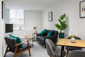a living room with a couch and a table at Queens Park by Viridian Apartments in London