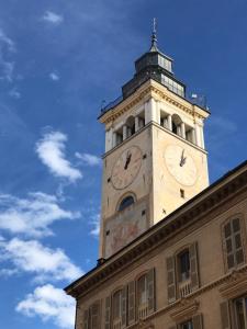 a clock tower on top of a building at VIRASOL IN CITTÁ, camera NUVOLE in Cuneo