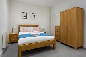 Un pat sau paturi într-o cameră la Queens Park by Viridian Apartments
