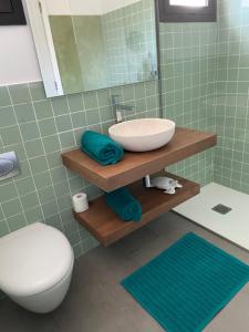 a bathroom with a sink and a toilet and a mirror at Splendide Villa les pieds dans l'eau dans la baie de Mahon in Es Castell +57 photos
