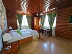 Schlafzimmer mit einem Bett, einem Tisch und Fenstern in der Unterkunft Vita Gasthof in Rastenfeld