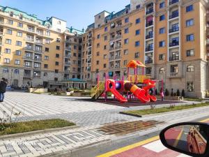 a playground in front of a large building at Guest house boulevard 1 in Sumqayıt