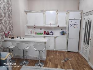 a kitchen with white cabinets and a refrigerator at Guest house boulevard 1 in Sumqayıt