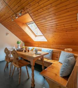 Holzzimmer mit einem Tisch und einem Dachfenster in der Unterkunft Haus am Grafenbächle in Bad Rippoldsau