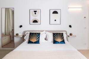 a bedroom with a white bed with blue and white pillows at MADA Charm Apartments Piazza in Vernazza