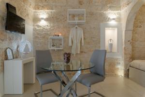 comedor con mesa de cristal y sillas en Pregiata Suite 25, en Ostuni