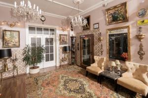 a living room with a chandelier and a rug at City Hotel Kaiserhof in Offenbach