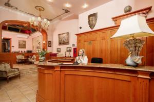 a woman sitting at a bar in a courtroom at City Hotel Kaiserhof in Offenbach