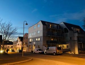 um edifício com carros estacionados em frente dele numa rua em Parken Terrasse Apartment Hotel em Kopervik