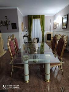 una mesa de cristal y sillas en una habitación en B&B Nonna Pina en Leporano