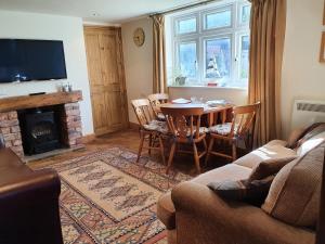 a living room with a table and a fireplace at The Coach House Holiday Cottage, Southport in Southport