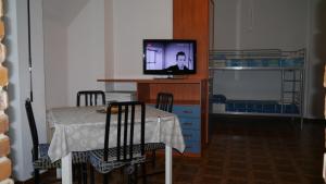 a dining room with a table and a tv on a desk at La casa di Dario in Pero