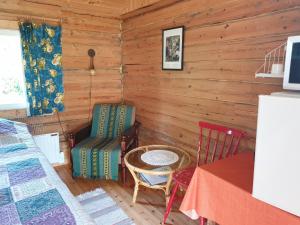 a room with a bed and a table and chairs at Nestorinranta Resort in Lintusalo