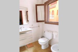 uma casa de banho com um WC, um lavatório e uma janela em Panoramic sea and Ifach views in Calpe em Calpe