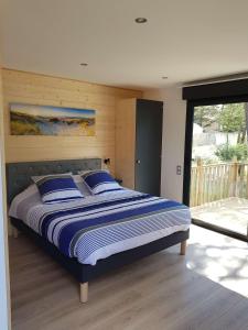 ラ・フォット・シュル・メールにあるChambre d'hôtes et Spa de la Presqu'îleのベッドルーム(青い枕の大型ベッド1台付)
