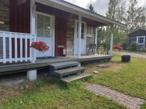 a porch of a house with a bench and flowers at Nestorinranta Resort in Lintusalo