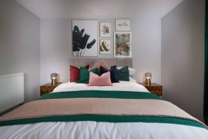1 dormitorio con 1 cama grande y almohadas coloridas en Roseland Apartment 1, en Arundel