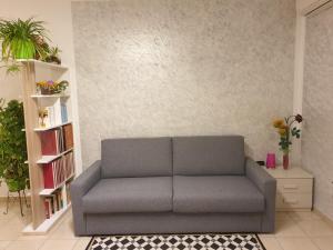 a gray couch in a living room with a book shelf at Casa di Anna in Todi