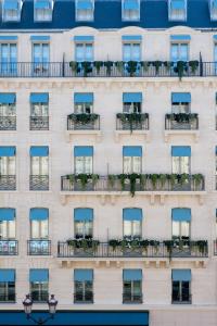 a facade of a building with blue windows and plants at Nolinski Paris in Paris