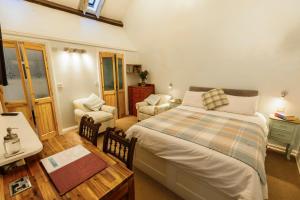 a bedroom with a bed and a table and chairs at Haddock Hideaway in Castleton