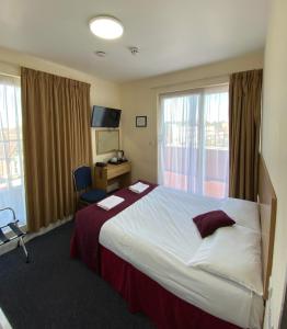 a hotel room with a large bed and a window at PremierLux Serviced Apartments in Ilford