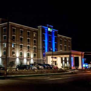 a building with blue lights in front of a parking lot at Holiday Inn Express & Suites Peekskill-Lower Hudson Valley, an IHG Hotel in Peekskill