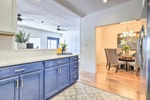a kitchen with blue cabinets and a dining room with a table at Renovated Dtwn Retreat Less Than 1 Mi to Plaza Park! in San Marcos