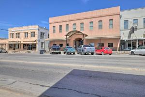 a city street with cars parked in front of a building at Renovated Dtwn Retreat Less Than 1 Mi to Plaza Park! in San Marcos