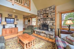 una sala de estar con una gran chimenea de piedra. en Adirondack Oasis Lake House with Dock and Deck!, en Schroon Lake