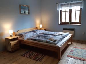 sypialnia z łóżkiem, 2 szafkami nocnymi i oknem w obiekcie U Kapitána w mieście Radvánovice