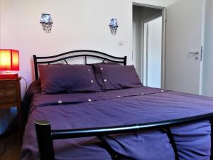 een slaapkamer met een bed met paarse lakens bij Location courte durée in Saumur