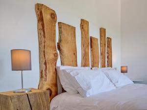 a bed with a wooden headboard and white pillows at Castelo de Arez in Alcácer do Sal