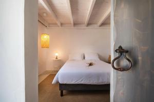 a bedroom with a bed with white sheets and a ceiling at Castelo de Arez in Alcácer do Sal