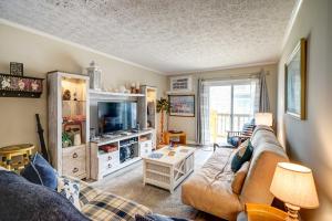 sala de estar con sofá y TV en Oceanfront Topsail Beach Retreat - Steps to Shore!, en North Topsail Beach