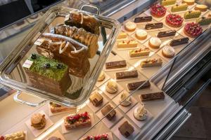 a display case filled with cakes and pastries at Cour des Vosges in Paris