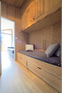 a bed in a room with wooden walls at Résidence Aiguille Lodge in Les Deux Alpes