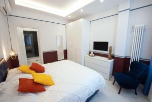 ein Schlafzimmer mit einem Bett, einem Stuhl und einem TV in der Unterkunft Napoli City Center - Appartamenti e Camere in Neapel