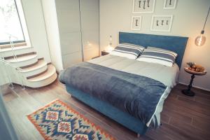 um quarto com uma cama com almofadas e um tapete em 800s Home Luxury Rooms em Ostuni