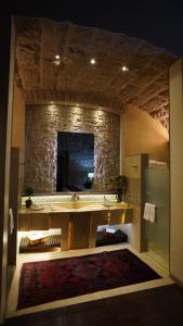 a bathroom with a sink and a stone wall at Hotel De La Soledad in Morelia