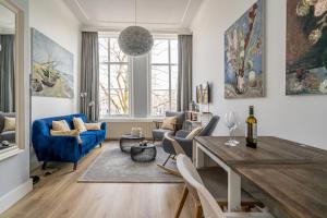 a living room with a blue couch and a table at De Witte Dame in Zierikzee