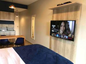 um quarto com uma televisão pendurada na parede em Flat 317 Granja Cotia Wi-Fi equipado e funcional em Cotia