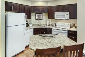 a kitchen with a white refrigerator and a table with chairs at WorldMark Pinetop in Pinetop-Lakeside